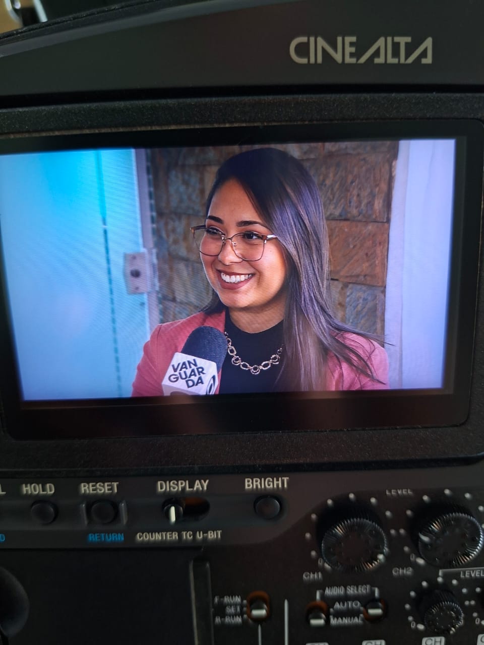 Danielly Paulino durante entrevista para a TV Vanguarda, vista no monitor da câmera
